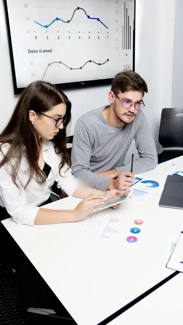 Top view of business team analyzing charts and data on paper for strategic planning.